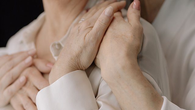Elderly hands embrace