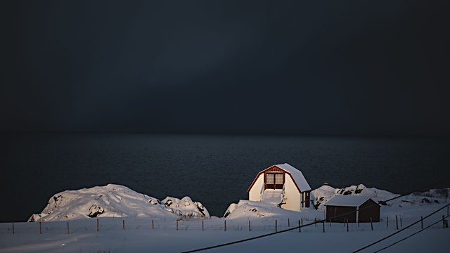 Lit barn dark sea snow