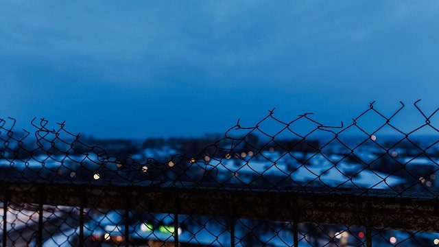 Broken chain link dusk cityscape